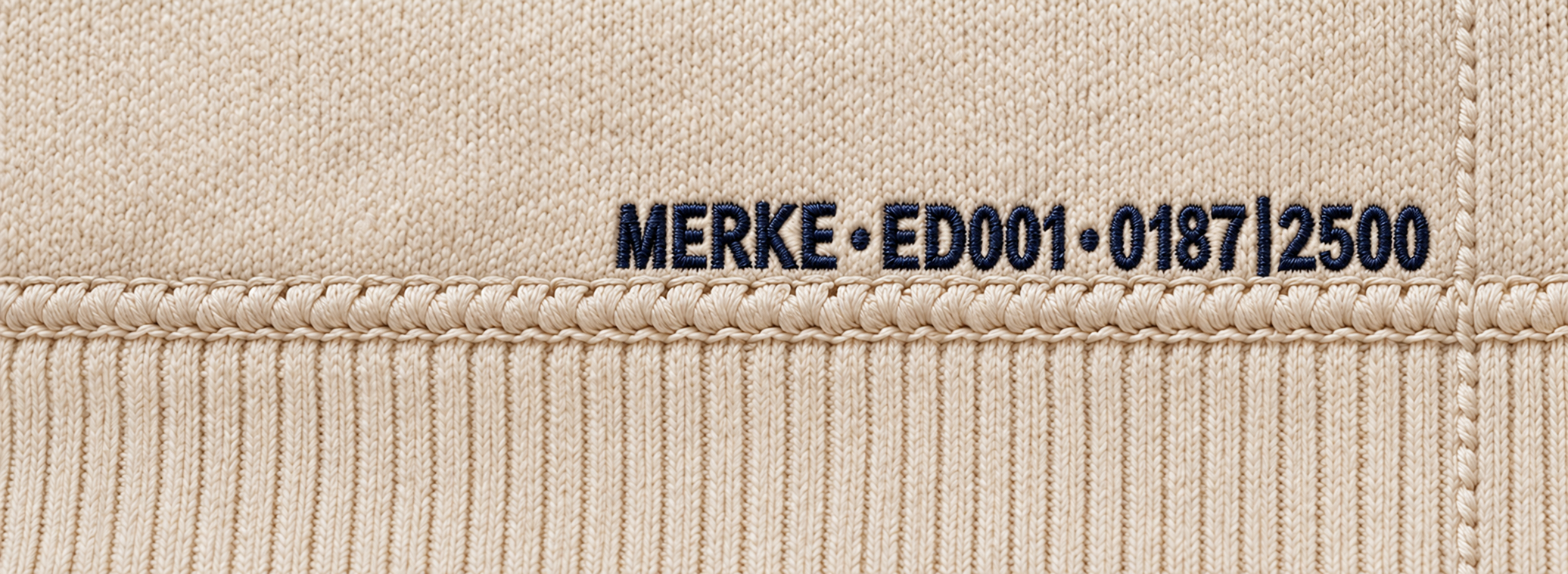 MERKE·ED001·0187|2500 embroidered in deep navy directly against the lower waistband joining seam, with tonal side-seam stitching to the right